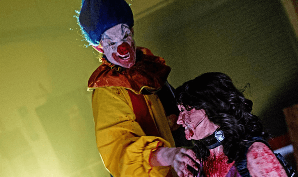A vampire clown grabbing a woman's shoulder with a clawed hand.